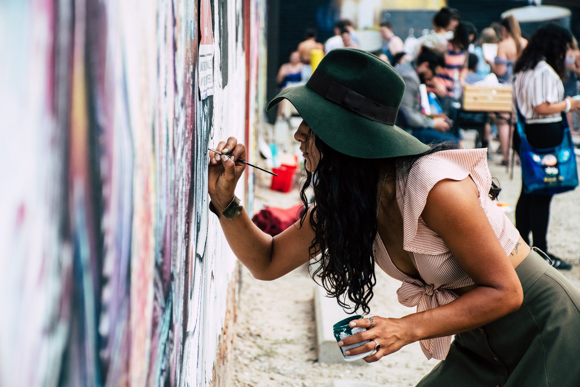 photo of woman painting on wall