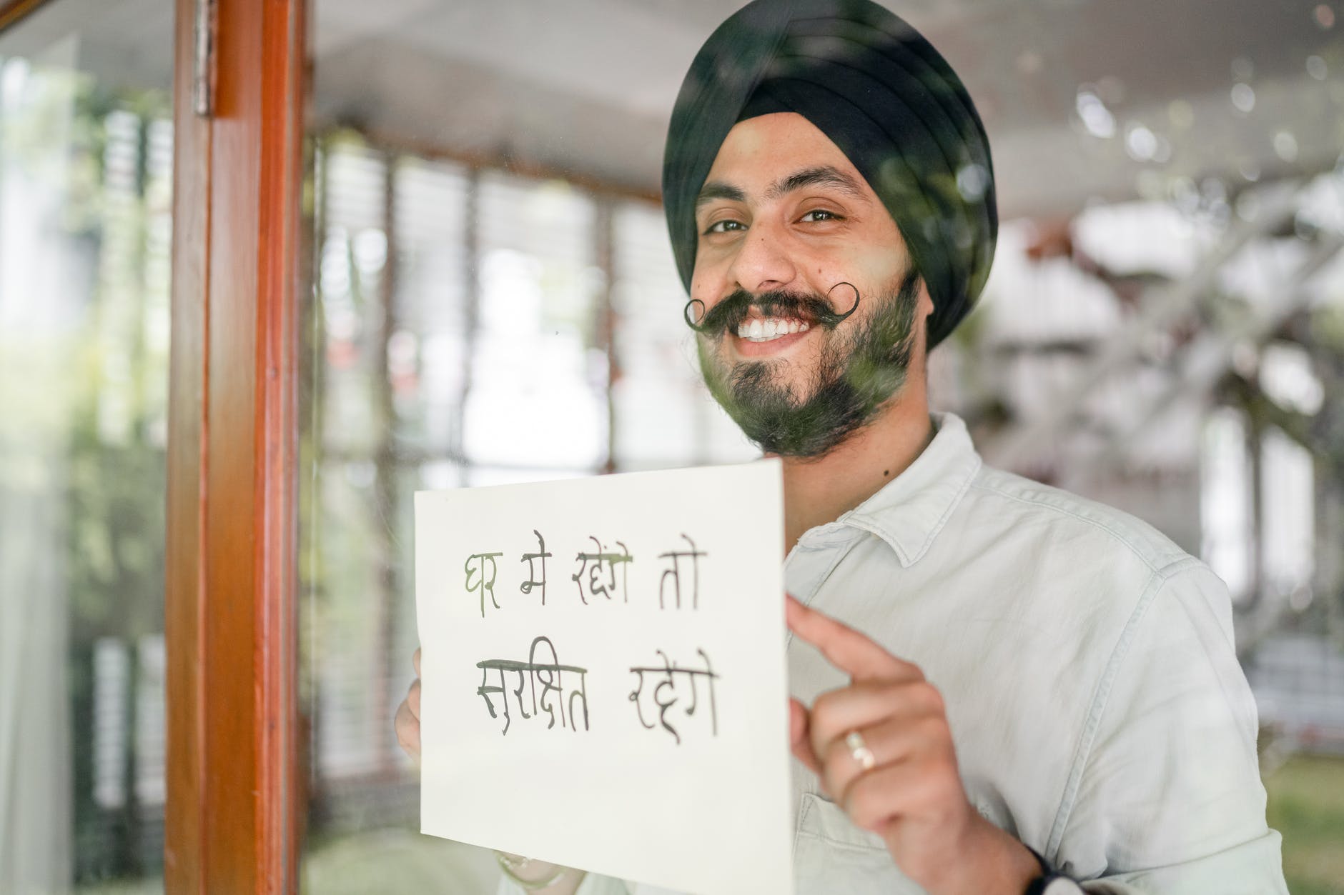 happy indian man in turban holding paper sheet